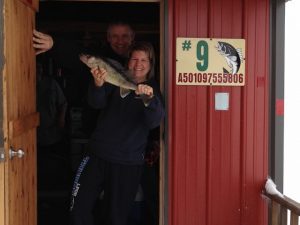 two people with fish in doorway red fish house